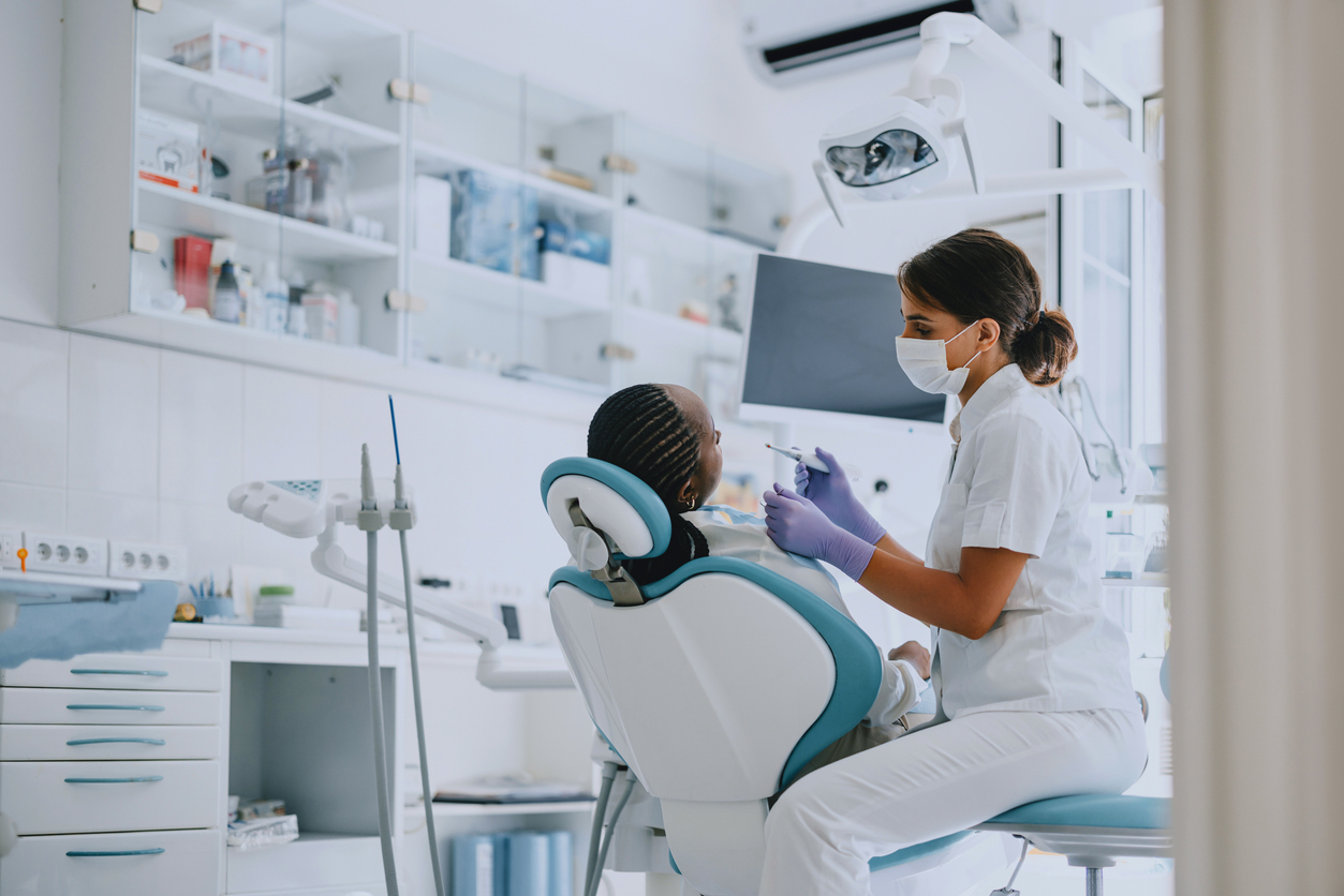 Dentist examining a patient in a modern dental clinic. Professional dental care and hygiene practice.