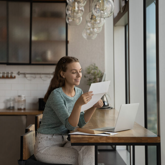 Happy,Young,Woman,Reading,Paper,Letter,At,Home,Workplace,With