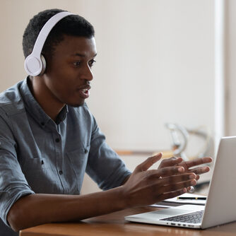 Serious,African,Businessman,Wearing,Wireless,Headphones,Makes,Conference,Video,Call