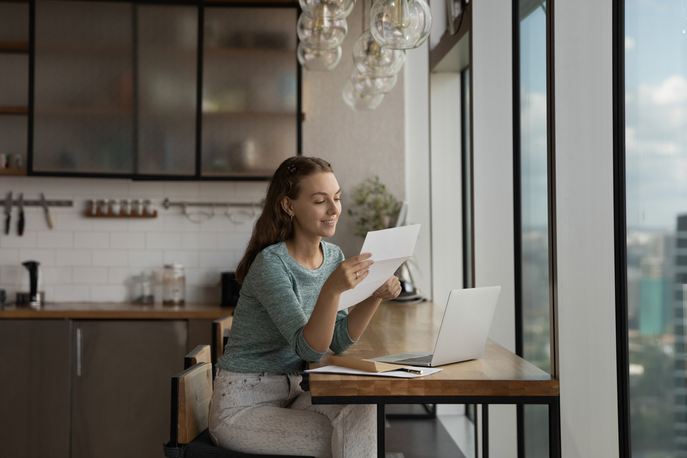 Happy,Young,Woman,Reading,Paper,Letter,At,Home,Workplace,With