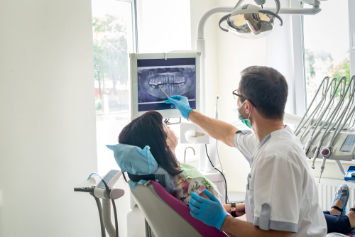 Doctor,Dentist,Showing,Patient's,Teeth,On,X-ray